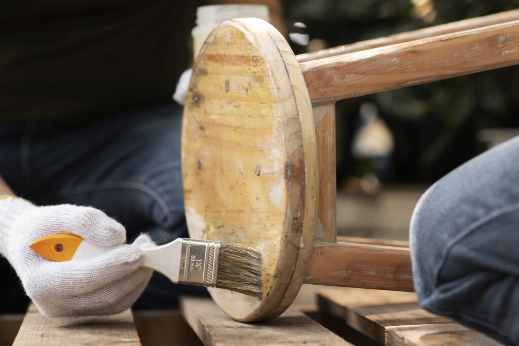 hand-using-brush-old-chair